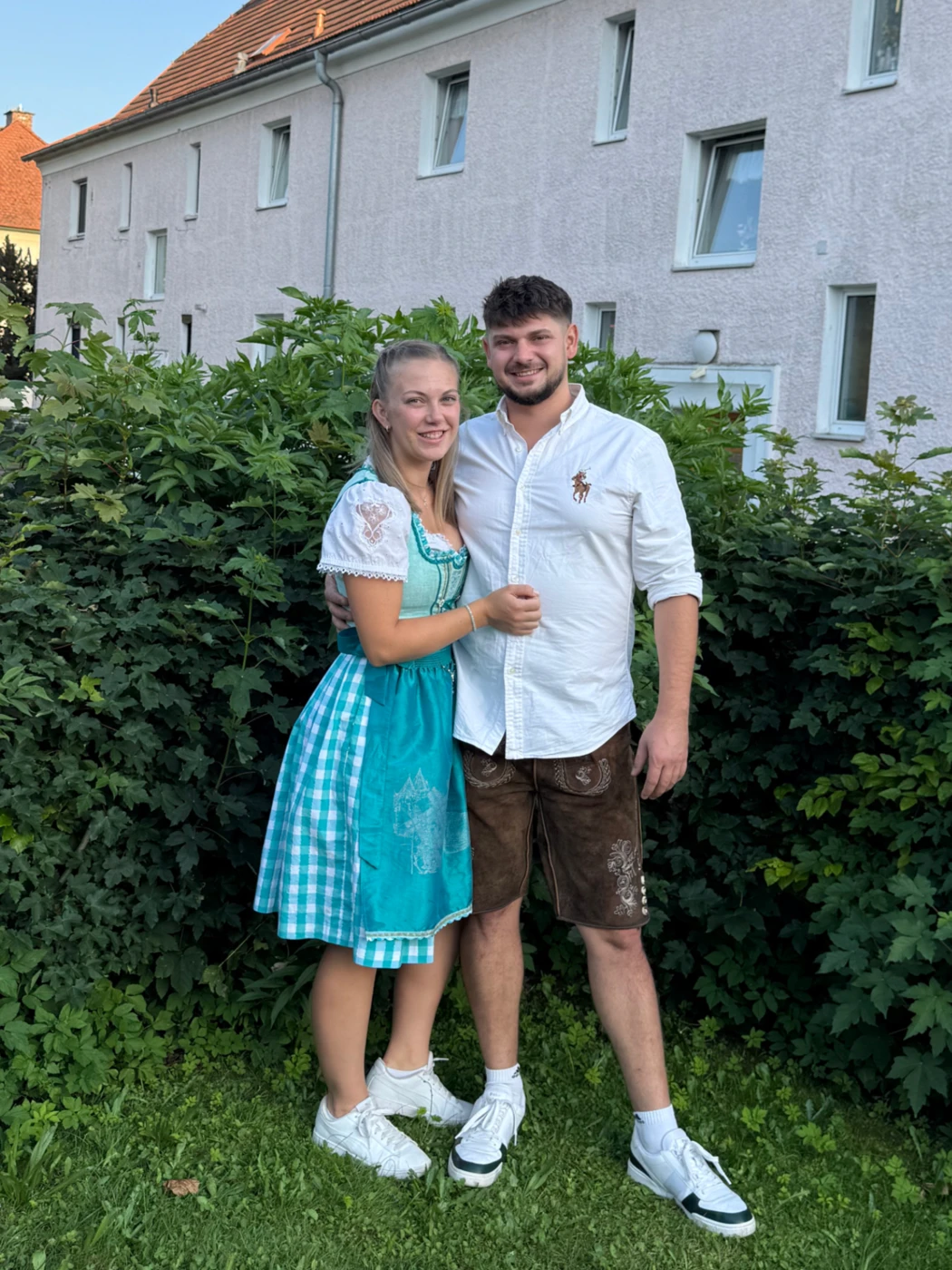 Lisa Hammer und Matthias Marjanovic gemeinsam in Tracht vor einer Hecke